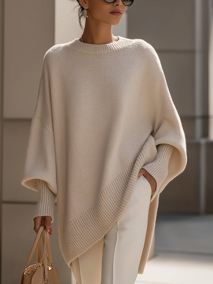 Kobieta prezentująca elegancki beżowy sweter oversize w miejskim otoczeniu