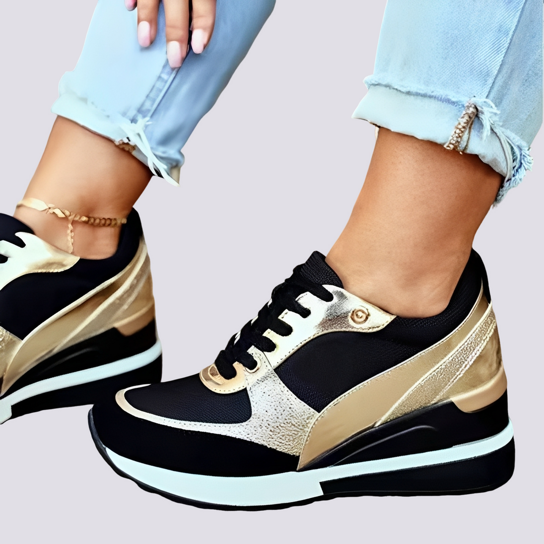 Damskie czarne sneakersy na platformie z ozdobnymi złotymi wstawkami zestawione z jasnymi dżinsami