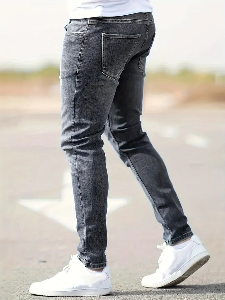 Widok z tyłu na męskie jeansy slim fit w kolorze szarym