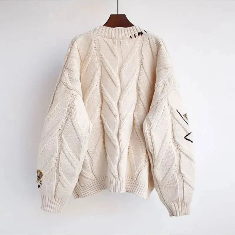 Beżowy sweter damski z dzianiny oversize prezentowany na sylwetce od tyłu