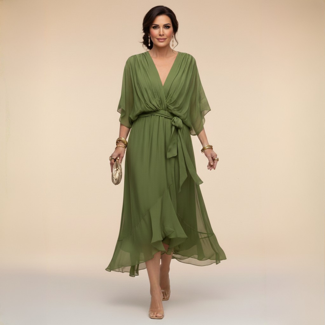 Kobieta w zielonej eleganckiej zwiewnej sukience midi