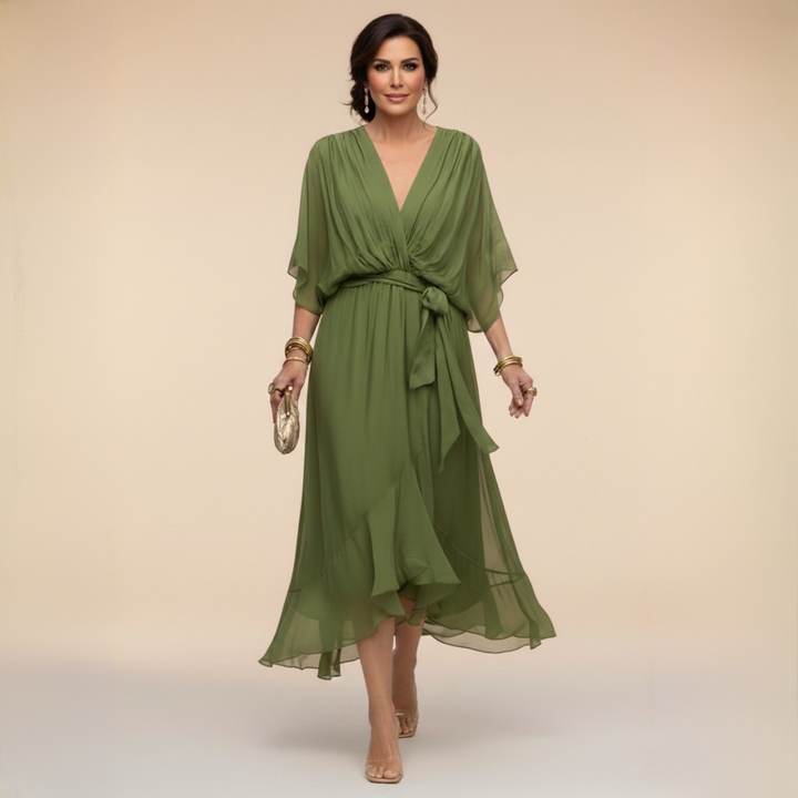 Kobieta w zielonej eleganckiej zwiewnej sukience midi