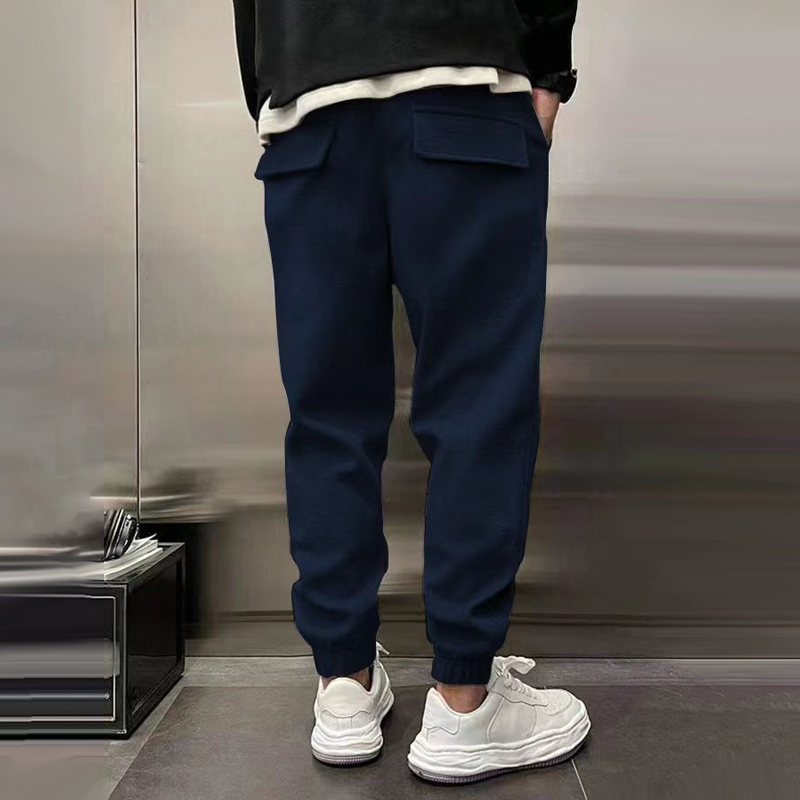 Szare spodnie męskie casual pokazujące nogawkę i ściągacz