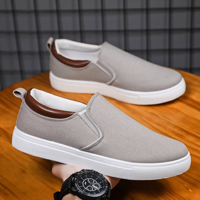 Szare męskie wsuwane sneakersy z oddychającą cholewką na tle ciemnej siatki