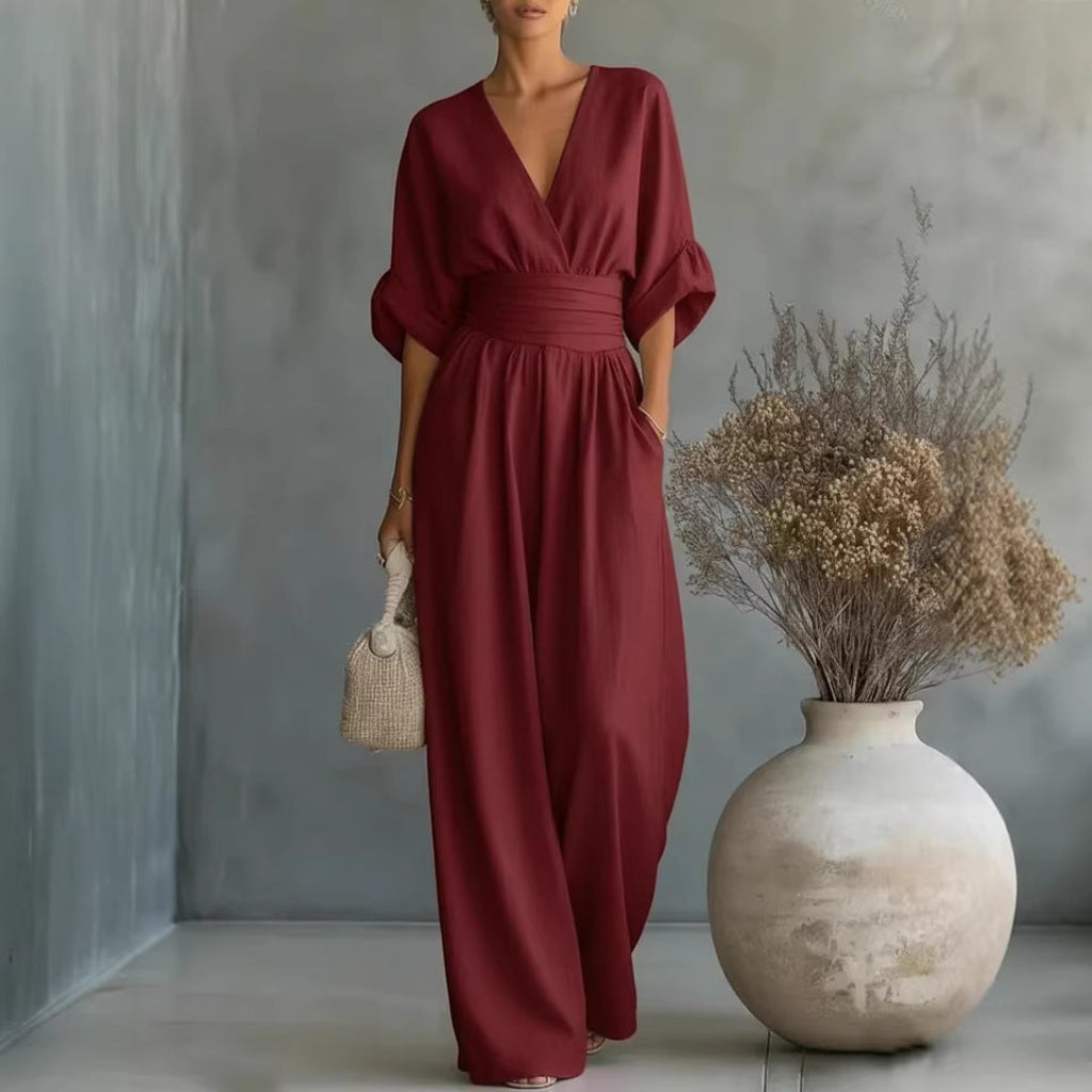 Kobieta w eleganckim ciemnoczerwonym kombinezonie damskim z dekoltem