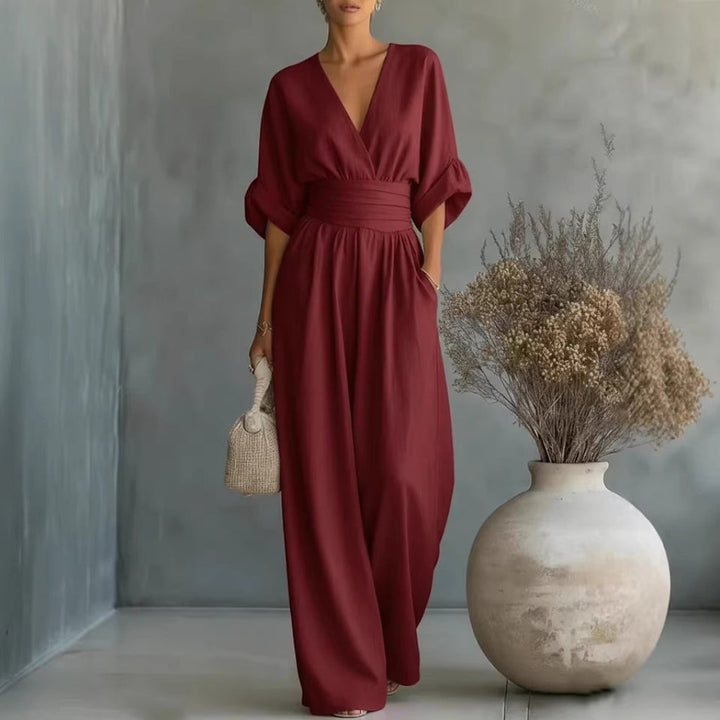 Kobieta w eleganckim ciemnoczerwonym kombinezonie damskim z dekoltem