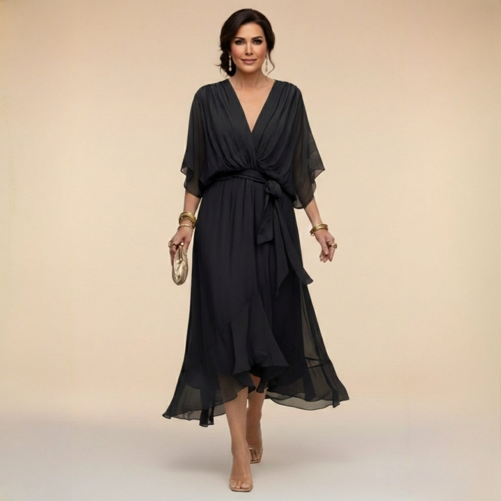 Kobieta w czarnej eleganckiej zwiewnej sukience midi