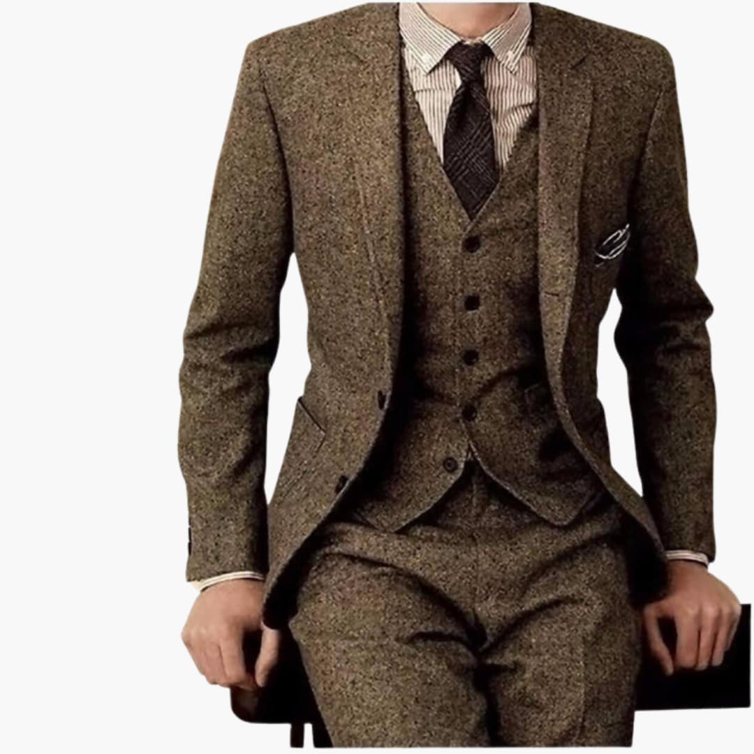 Mężczyzna siedzący w eleganckim brązowym garniturze trzyczęściowym z krawatem