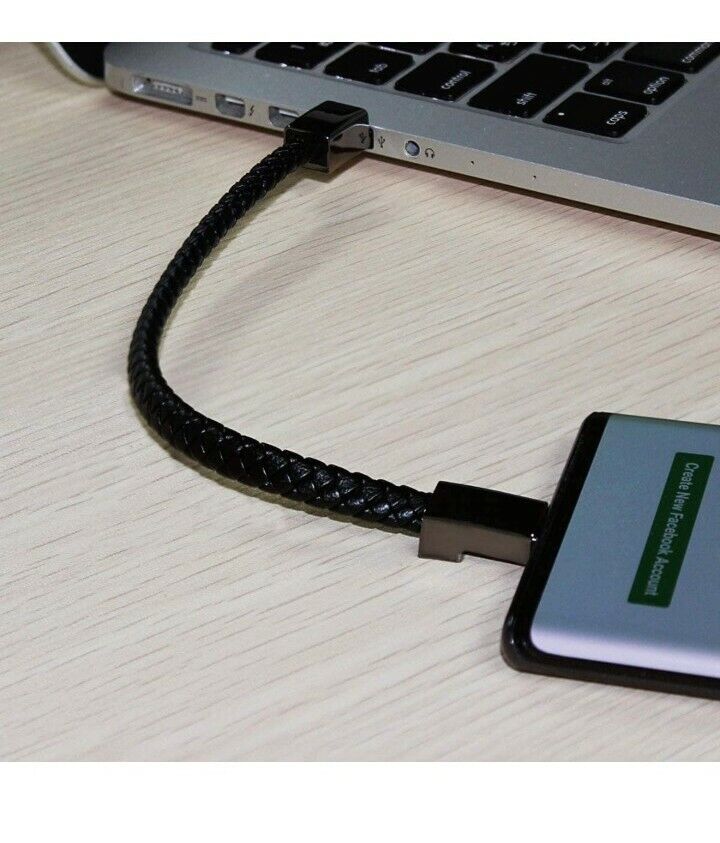 Zbliżenie na bransoletkę USB podłączoną do laptopa podczas ładowania telefonu