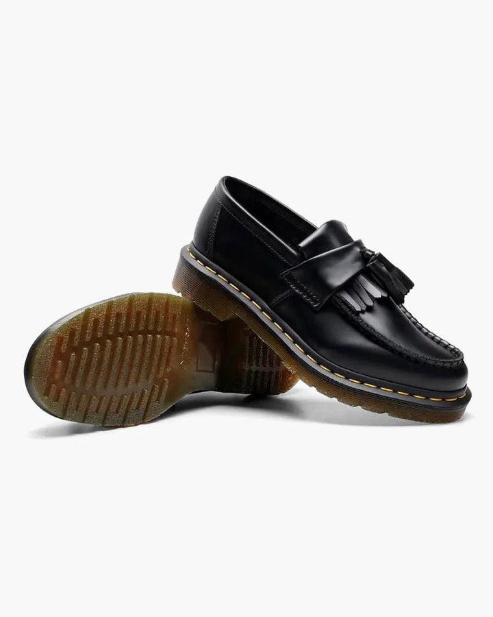 Podeszwa męskich loafersów prezentowana obok buta w kolorze czarnym