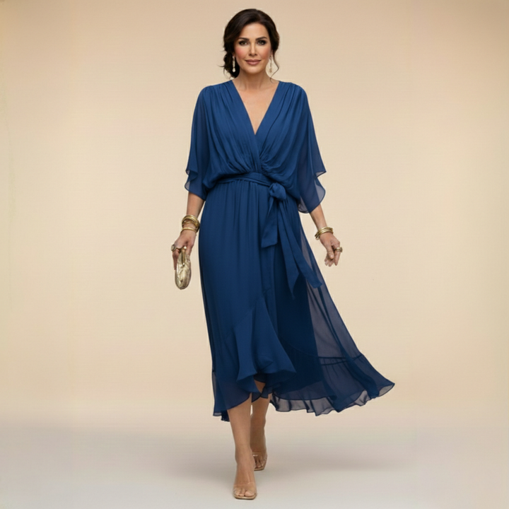 Kobieta w niebieskiej eleganckiej zwiewnej sukience midi