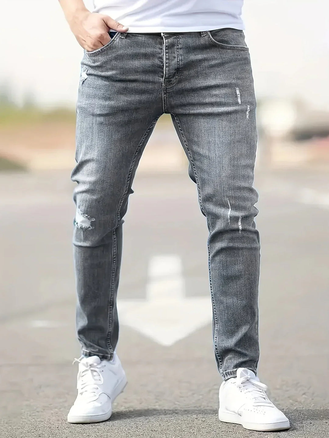 Mężczyzna w szarych męskich jeansach slim fit prezentujący nowoczesny krój