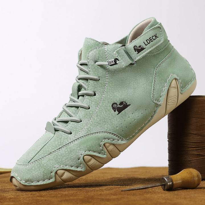 Stylizowane zielone buty barefoot obok narzędzia rzemieślniczego