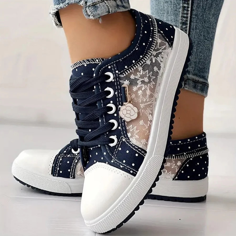 Zbliżenie na kwiatowy haft i siateczkę w błękitnych sneakersach damskich