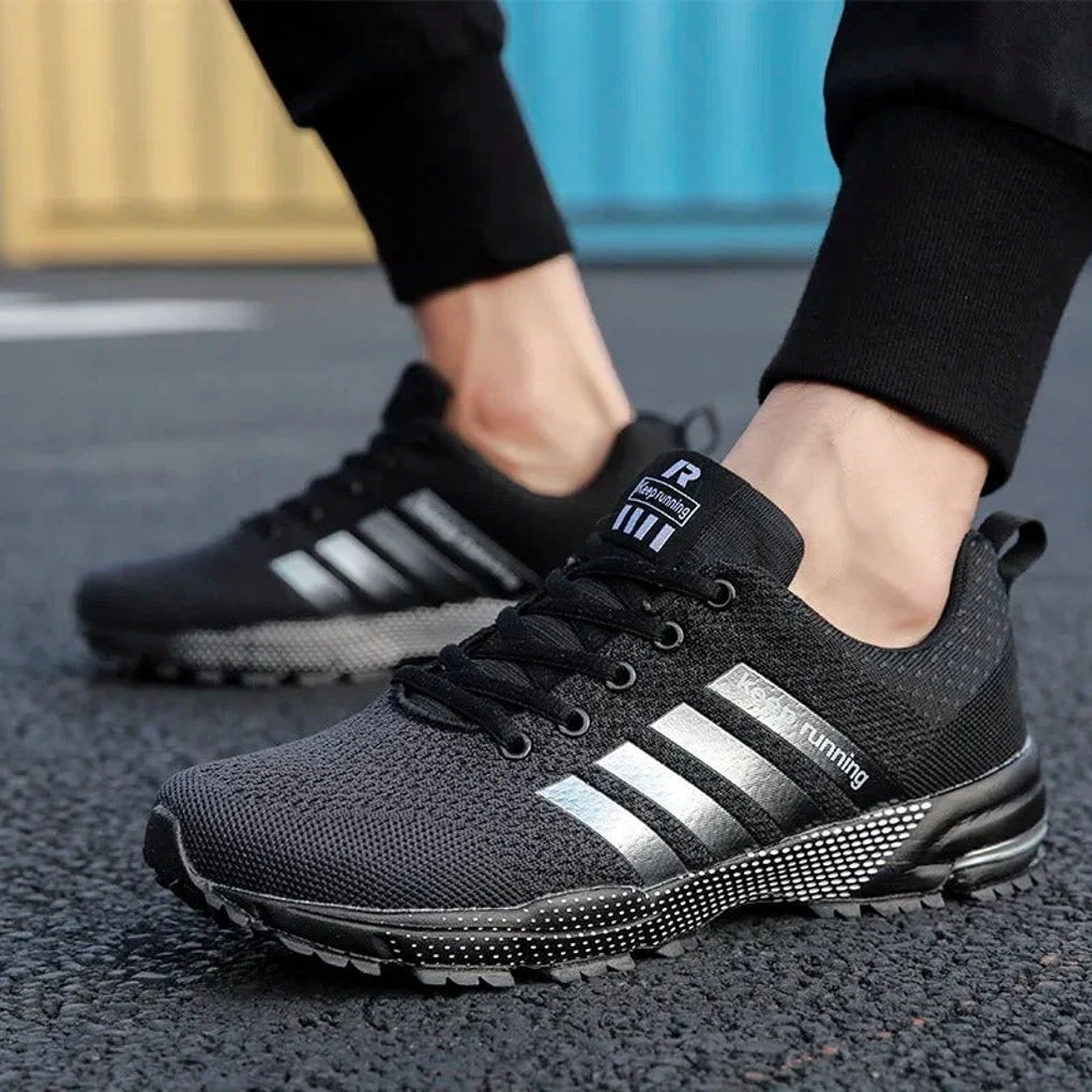Męskie czarne buty do biegania prezentowane na nodze w plenerze