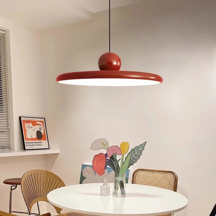 Czerwona lampa wisząca LED zamontowana nad stołem w nowoczesnej jadalni