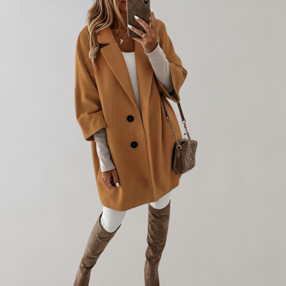 Kobieta w kurtce damskiej oversize w kolorze khaki na tle ściany