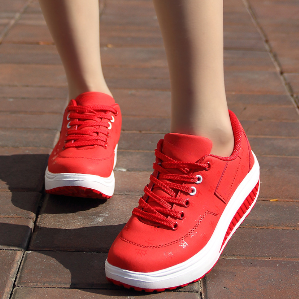 Czerwone damskie sneakersy sportowe na platformie prezentowane na stopach