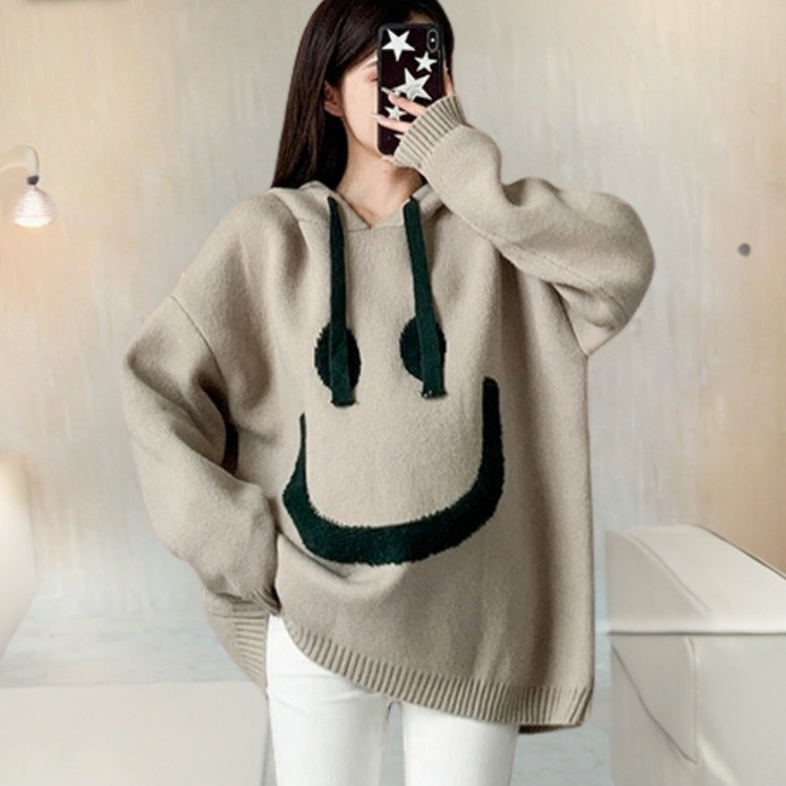 Kobieta w morelowym swetrze oversize z kapturem