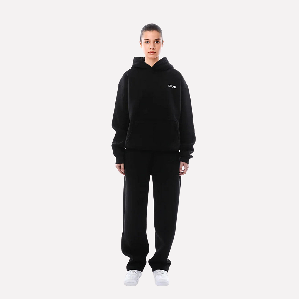 Kobieta prezentująca czarny dres unisex z bluzą i spodniami