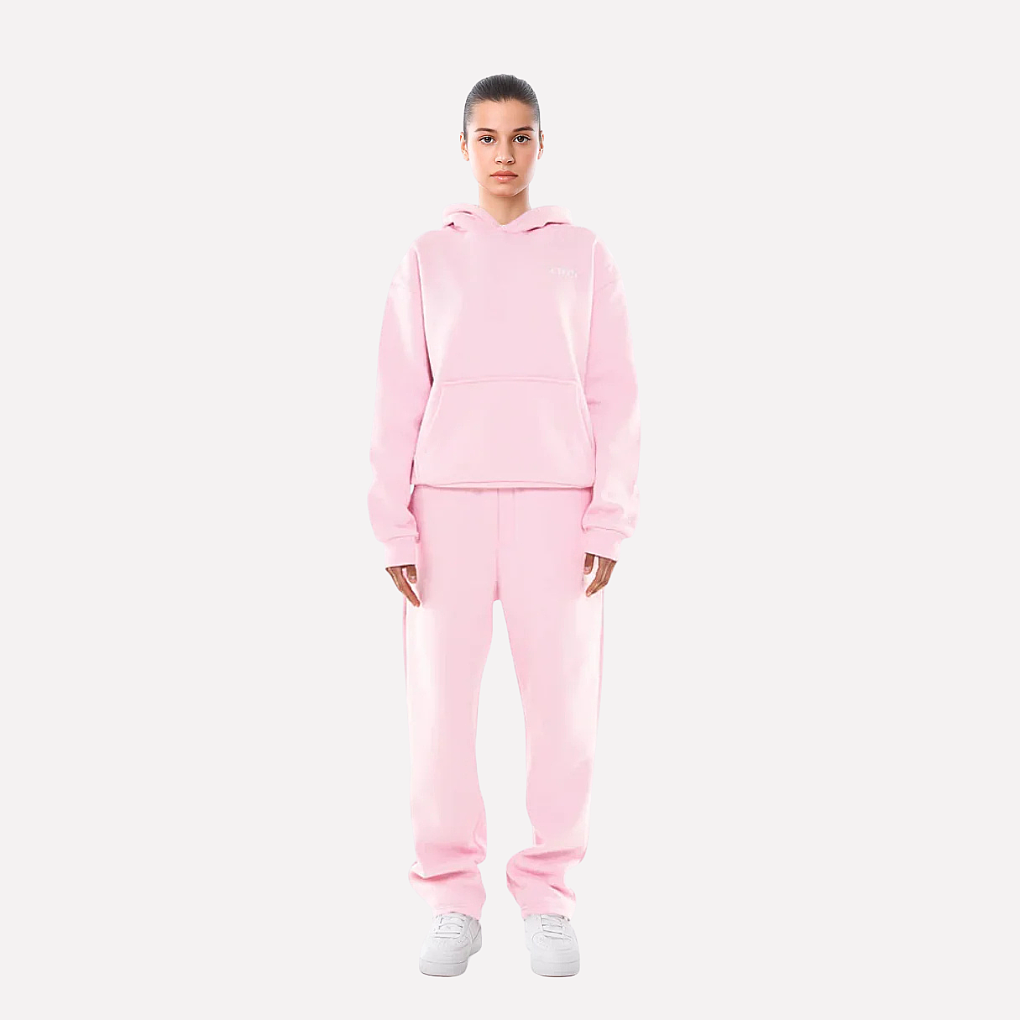 Kobieta w różowym dresie sportowym unisex stojąca przodem
