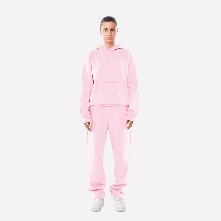 Kobieta w różowym dresie sportowym unisex stojąca przodem