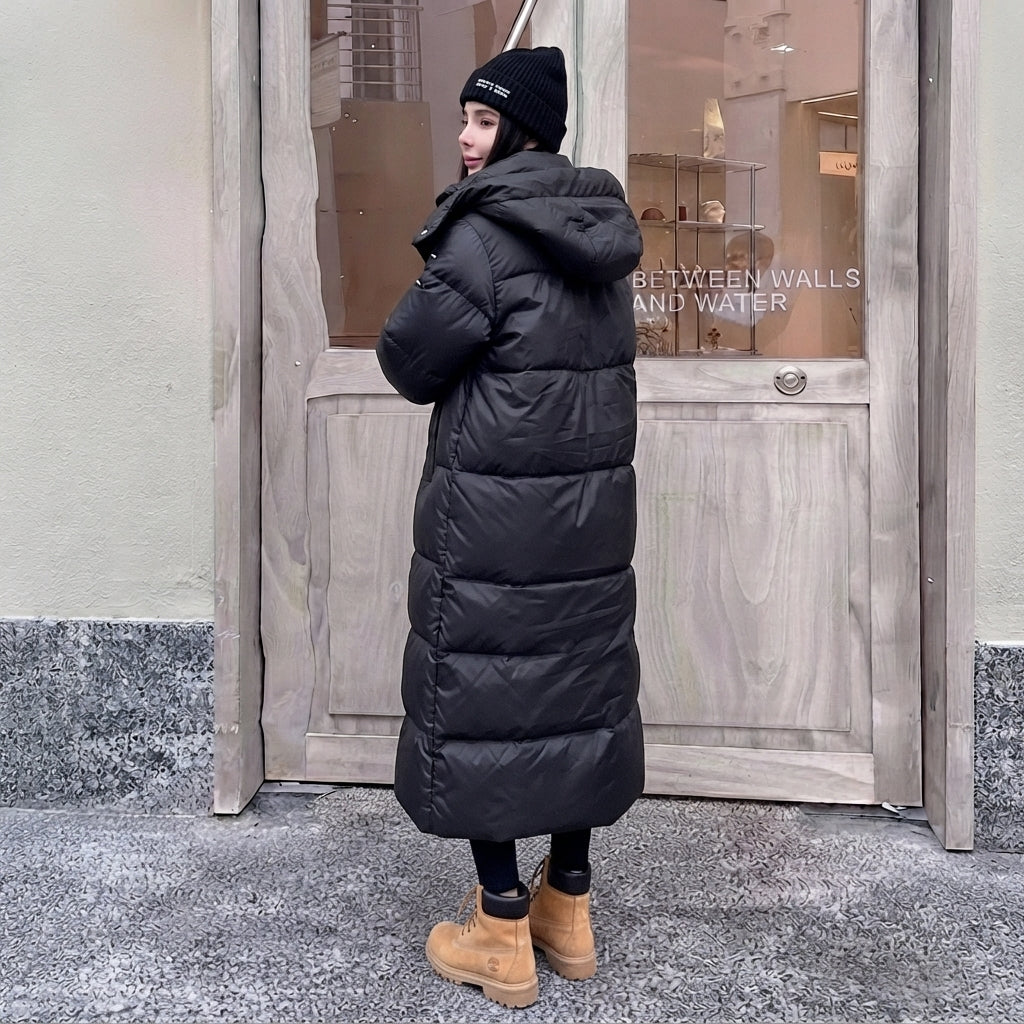 Czarny długi płaszcz zimowy damski w stylu oversize z kapturem i pikowaniem