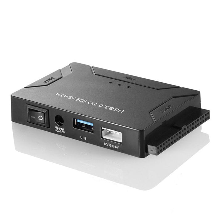 Adapter USB do SATA i IDE z podłączonymi kablami i zasilaczem na biurku