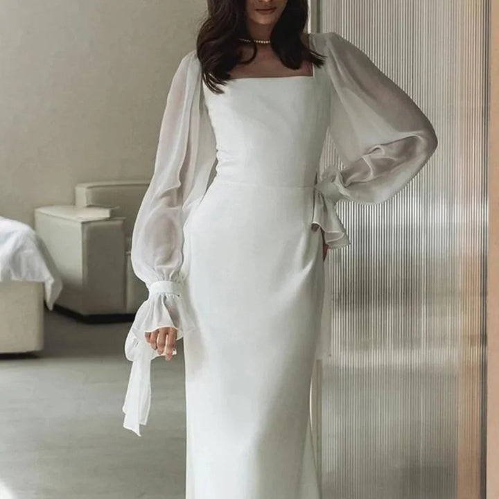 Kobieta w eleganckiej białej sukience z bufiastymi rękawami