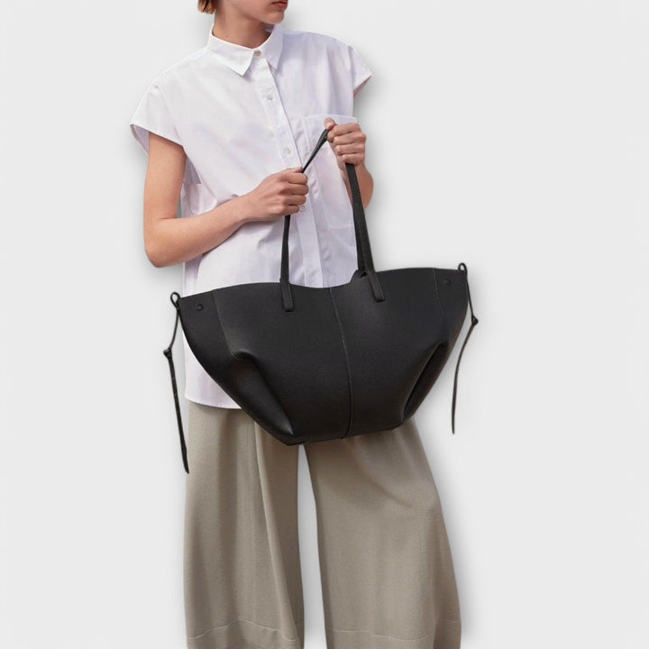 Czarna torebka na ramię prezentowana na modelce, modna stylizacja