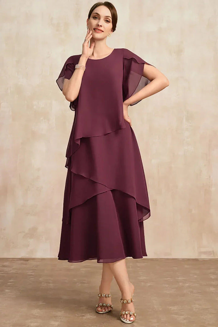 Modelka w brązowej eleganckiej sukience midi podczas pokazu mody