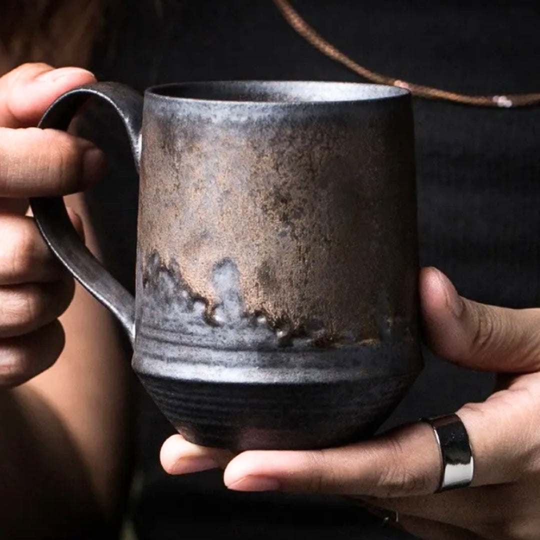 Ręcznie wykonany kubek ceramiczny trzymany w dłoniach