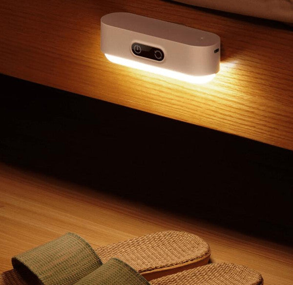 Lampka nocna LED świecąca ciepłym światłem nad podłogą w sypialni