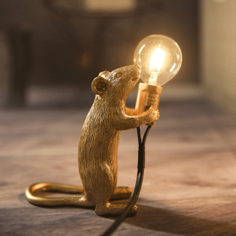 Złota lampa mysz LED włączona na drewnianym blacie