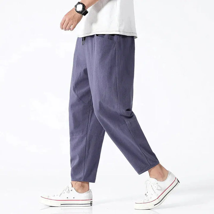 Mężczyzna w indygo spodniach tapered cropped z białymi tenisówkami