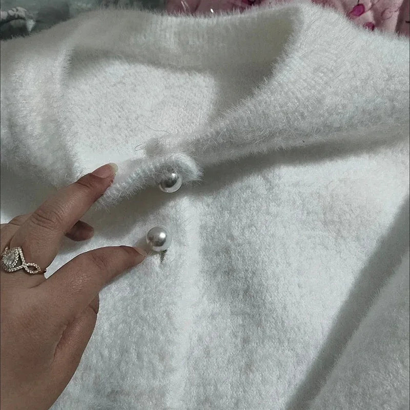 Elegancki sweter damski z perłowymi guzikami – widok zbliżenia na detale zapięcia i splot