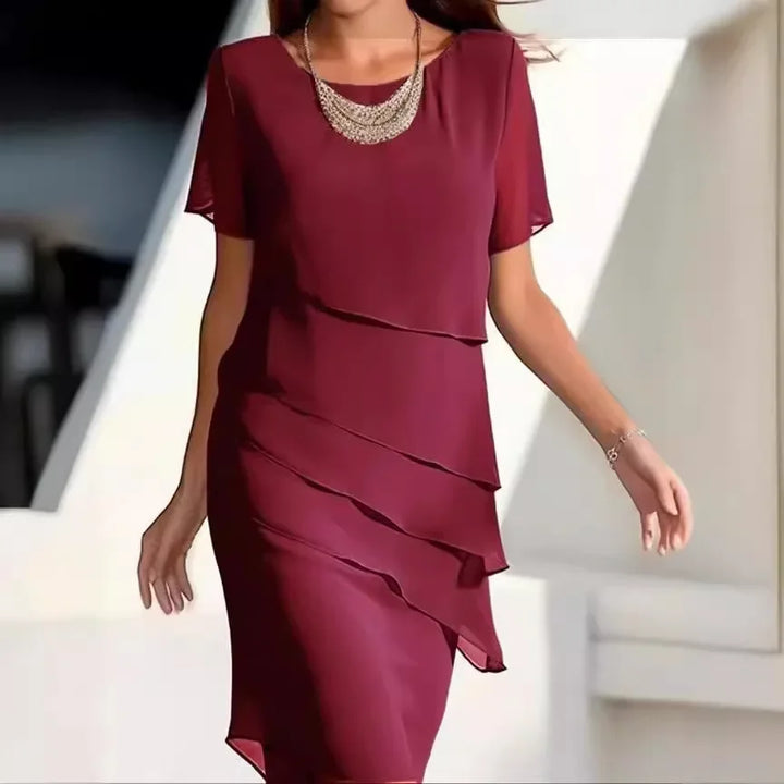 Modelka w bordowej eleganckiej sukience warstwowej na wesele