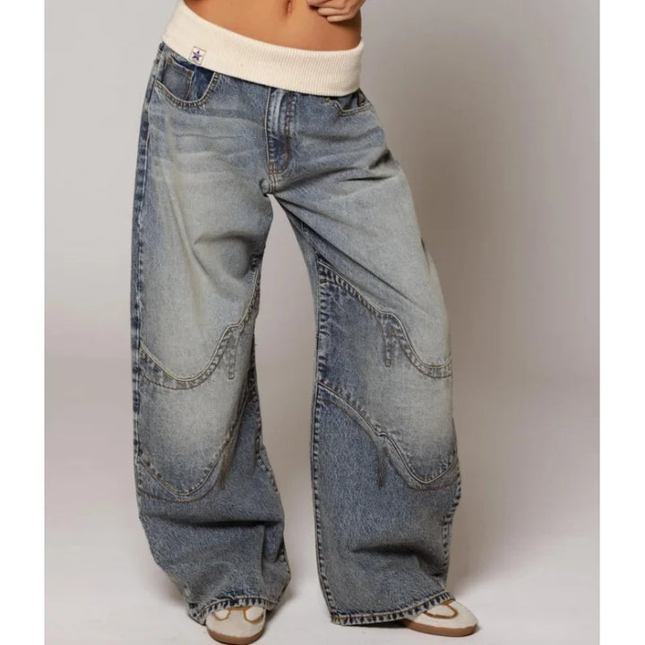 Kobieta stojąca w jasnoniebieskich jeansach baggy w stylu Y2K z szeroką nogawką