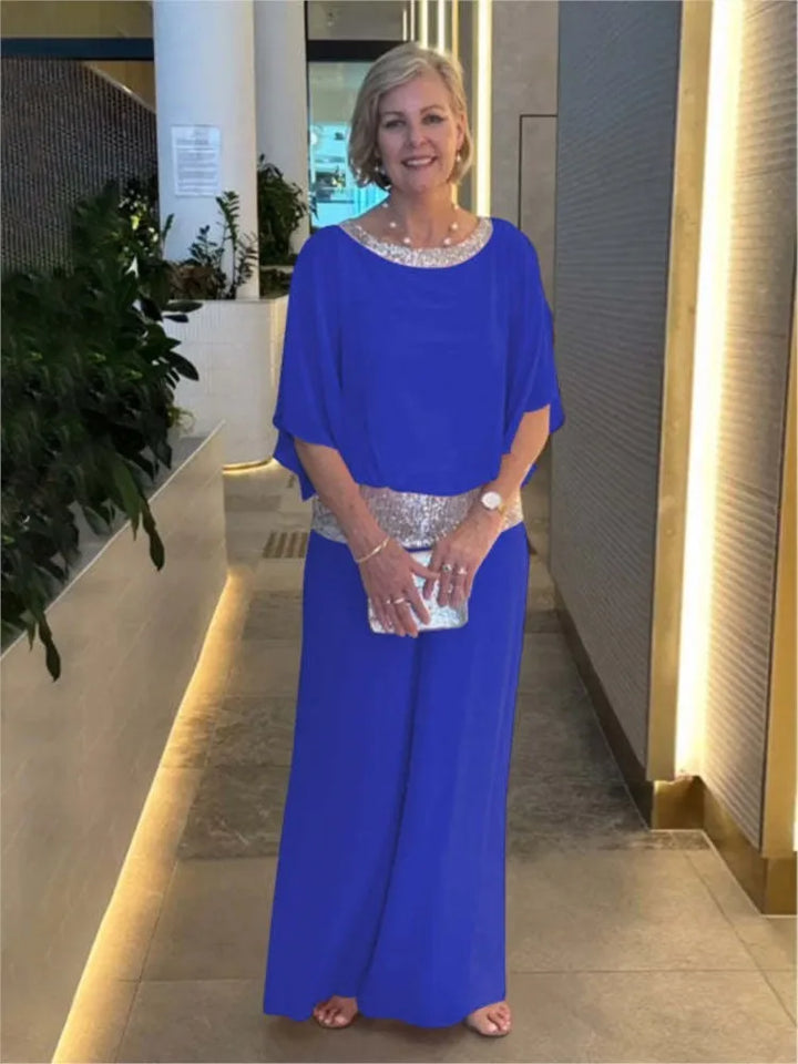 Kobieta stojąca w niebieskim eleganckim komplecie dwuczęściowym