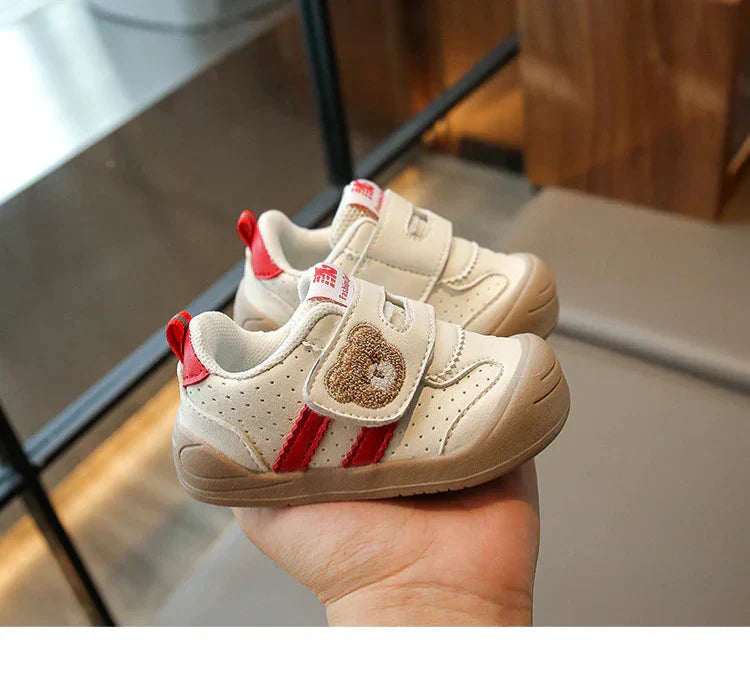 Dziecięce trampki Gleb w kolorze khaki z motywem misia trzymane w dłoni