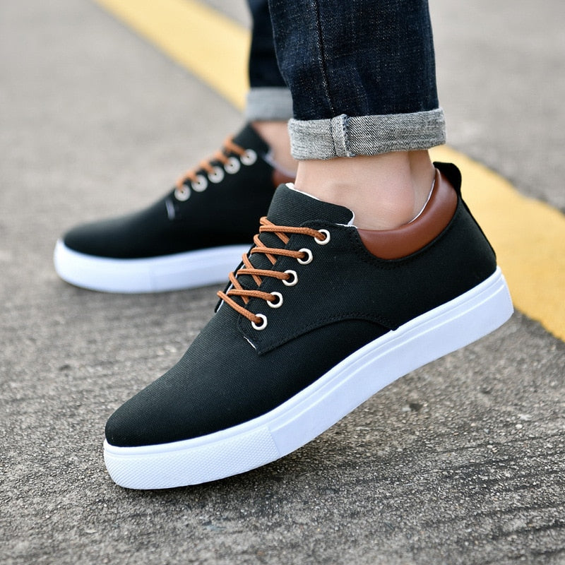 Męskie czarne sneakersy codzienne z brązowymi akcentami prezentowane na nodze