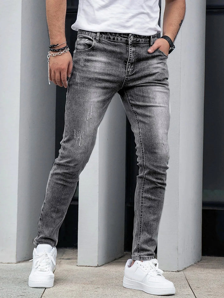 Męskie dopasowane jeansy skinny w kolorze szarym prezentujące modne wykończenie