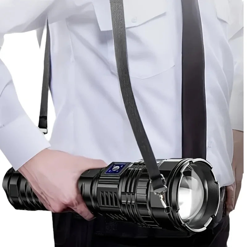 Mężczyzna trzymający dużą czarną latarkę LED Striker z paskiem