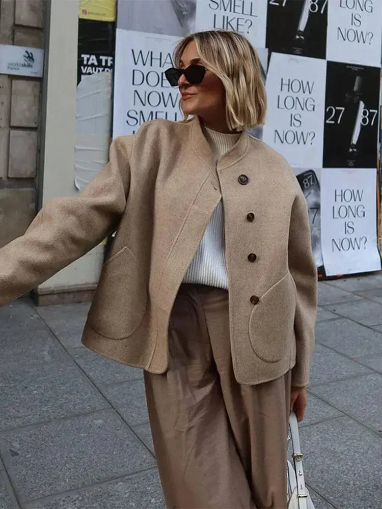 Kobieta w eleganckiej kurtce oversize khaki z asymetrycznym zapięciem