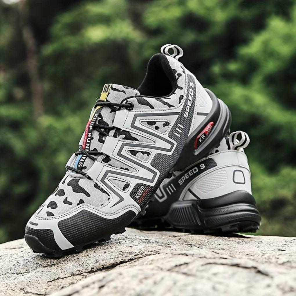 Białe buty trekkingowe z widocznym bieżnikiem na kamieniu