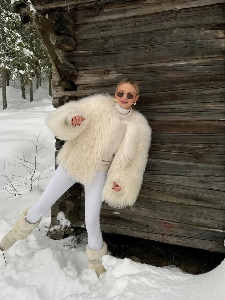 Stylowa kobieta w puszystym futrze i białych spodniach