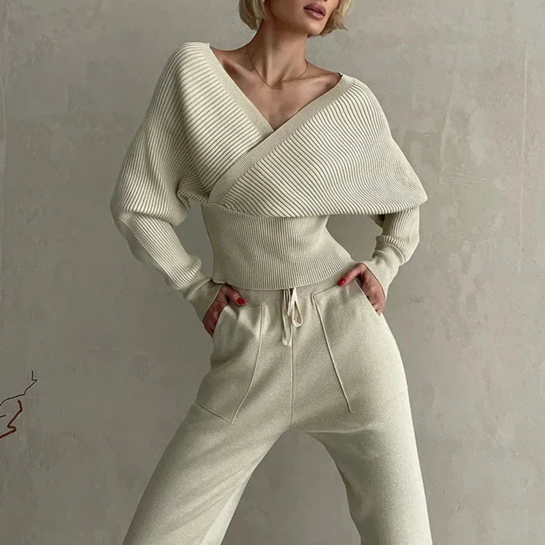 Kobieta prezentująca elegancki damski komplet sweter i spodnie w odcieniu ecru