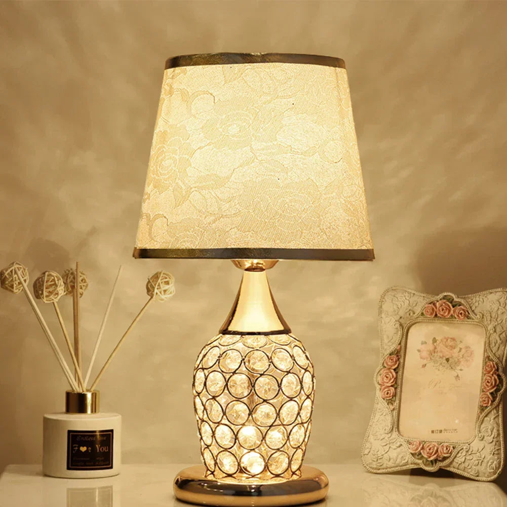 Stylowa lampa stołowa z kryształową podstawą i abażurem na stoliku nocnym