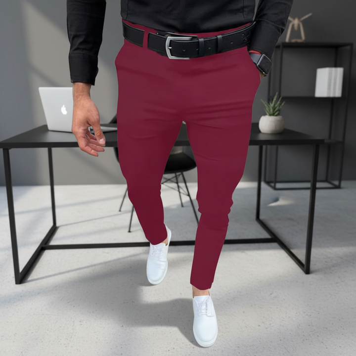 Mężczyzna w bordowych spodniach slim fit Pascal i czarnej koszuli przy biurku