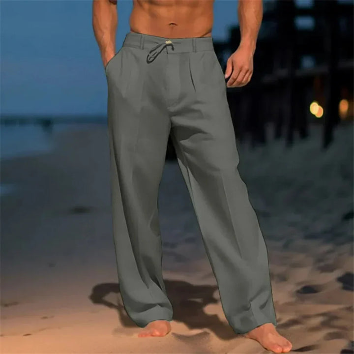 Mężczyzna w szarych eleganckich spodniach letnich na plaży